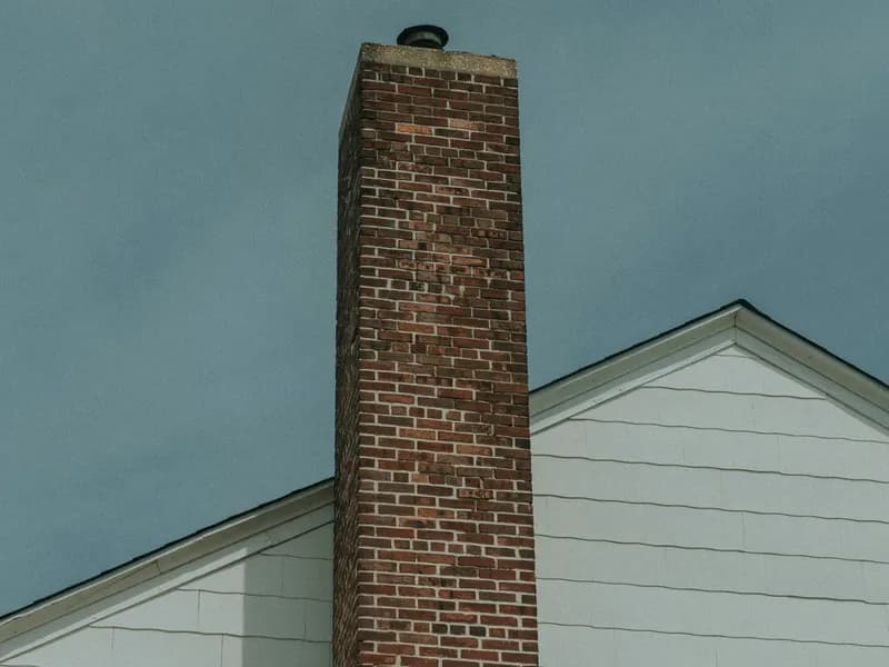 Clean brick chimney on white house